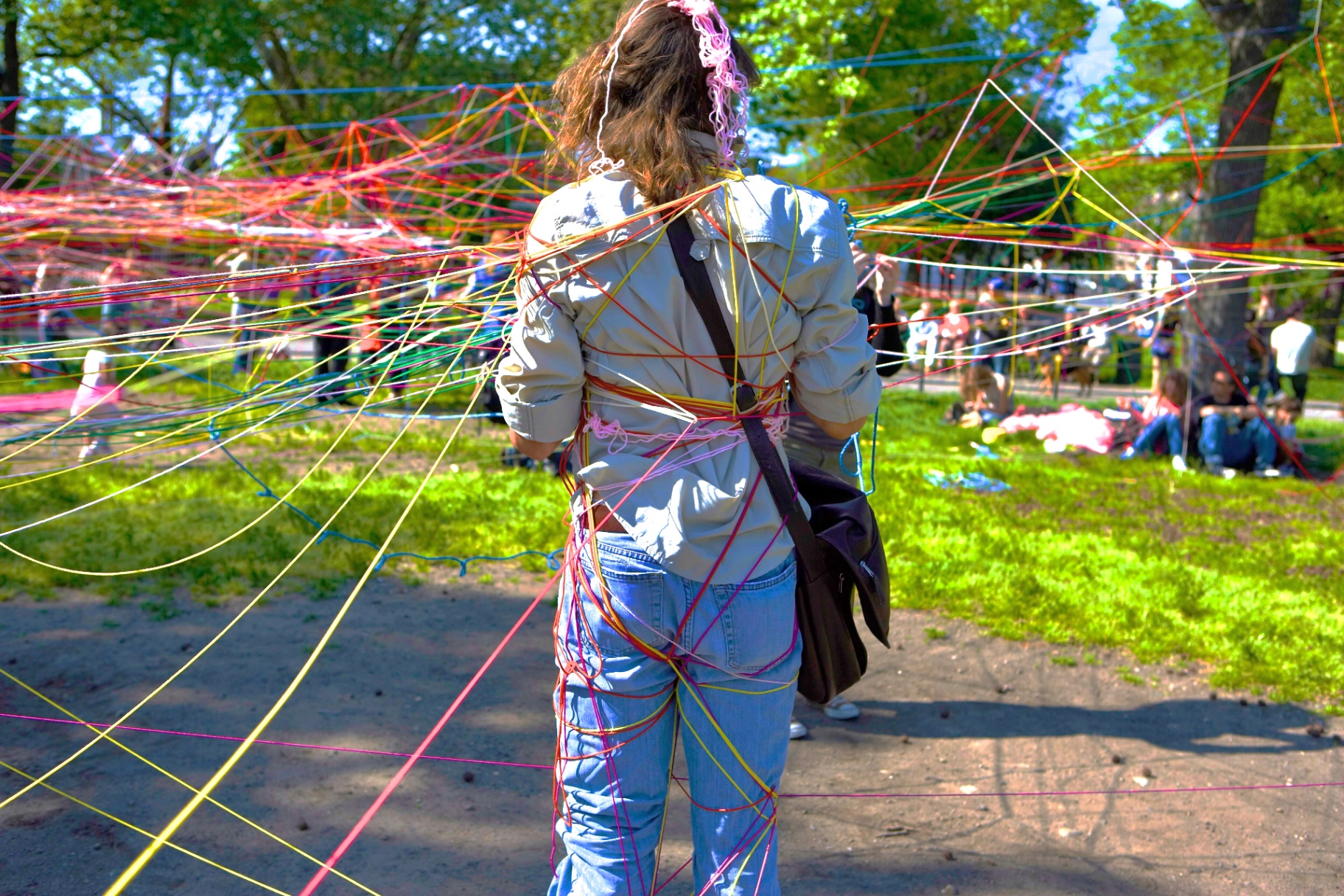 A woman walking through a vibrant string installation